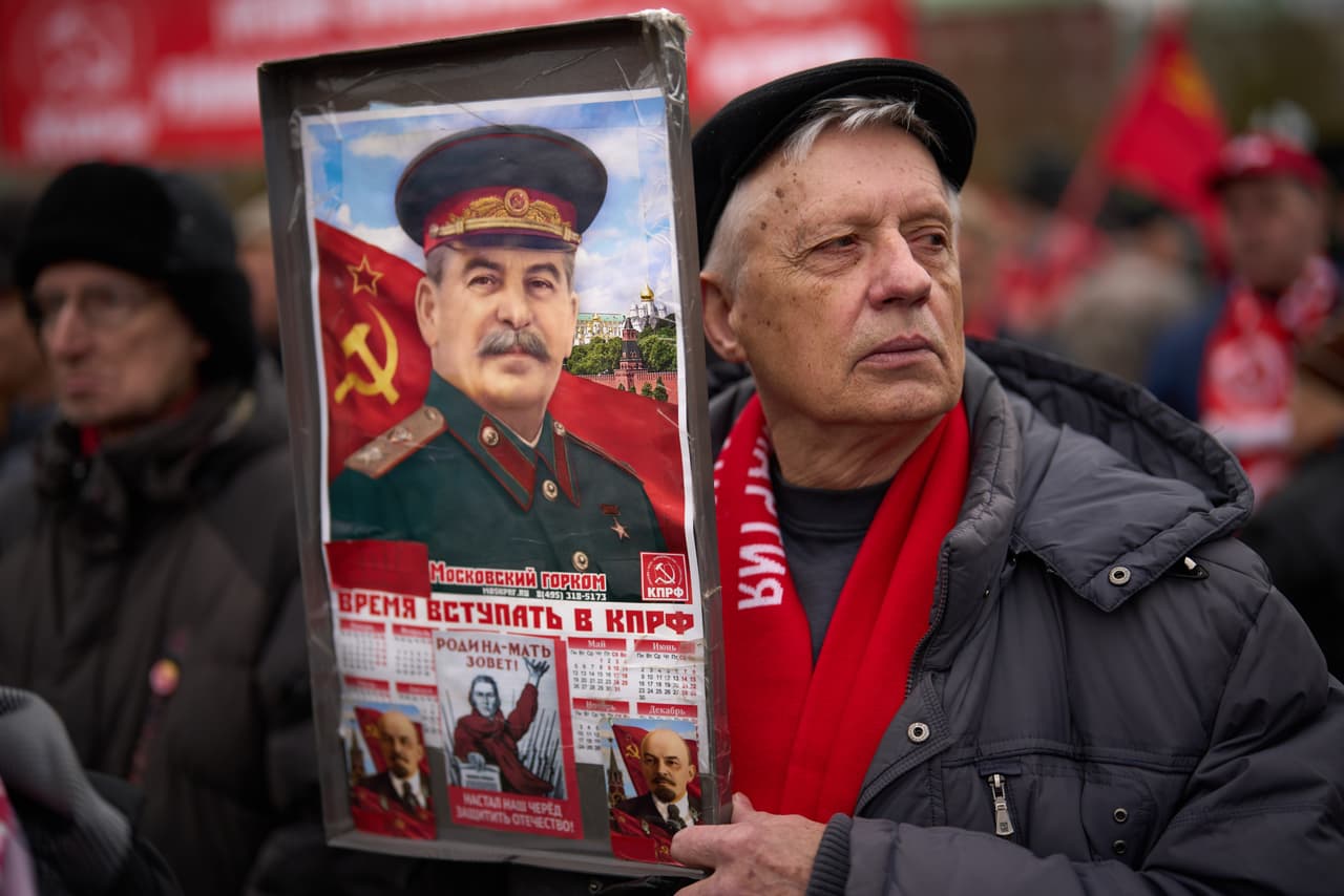 Un hombre sostiene un cartel con la imagen del exlíder soviético Josef Stalin mientras él y otros simpatizantes del Partido Comunista Ruso se reúnen para conmemorar el Día del Trabajo, también conocido como Primero de Mayo, en el monumento al filósofo alemán del siglo XIX Karl Marx, cerca de la Plaza Roja en Moscú.