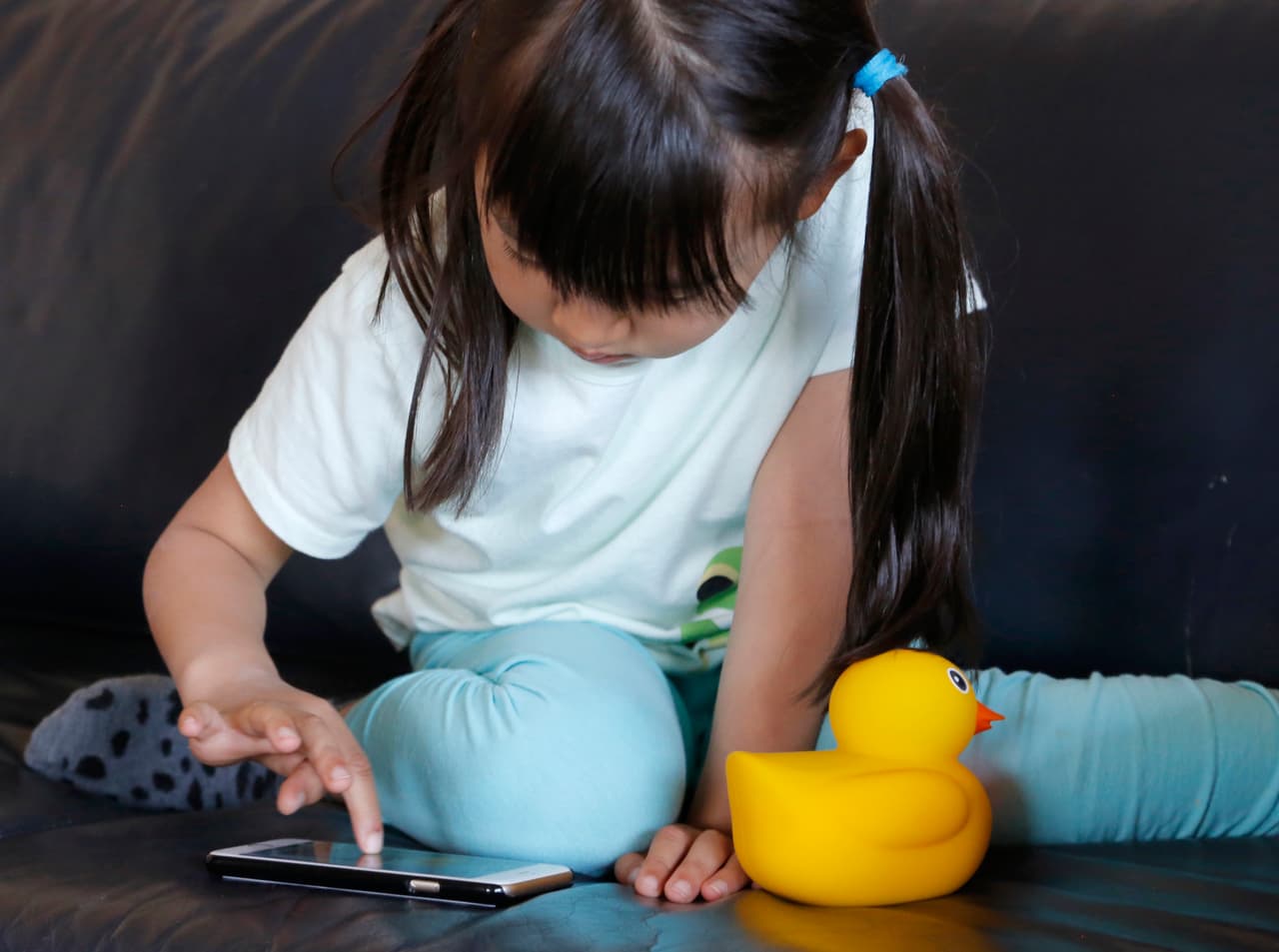 In this Monday, May 23, 2016, photo, Kano Matusmoto, 5, plays with Edwin the Duck, a digital duck toy, in the living room of her home in Tokyo. Edwin the Duck, billed as the worlds first smart duck, connects by Bluetooth with a smartphone or tablet device such as an iPad to play animation stories and songs. It also works as a regular speaker to deliver music of your choice in bed or in the bathtub. (AP Photo/Yuri Kageyama)