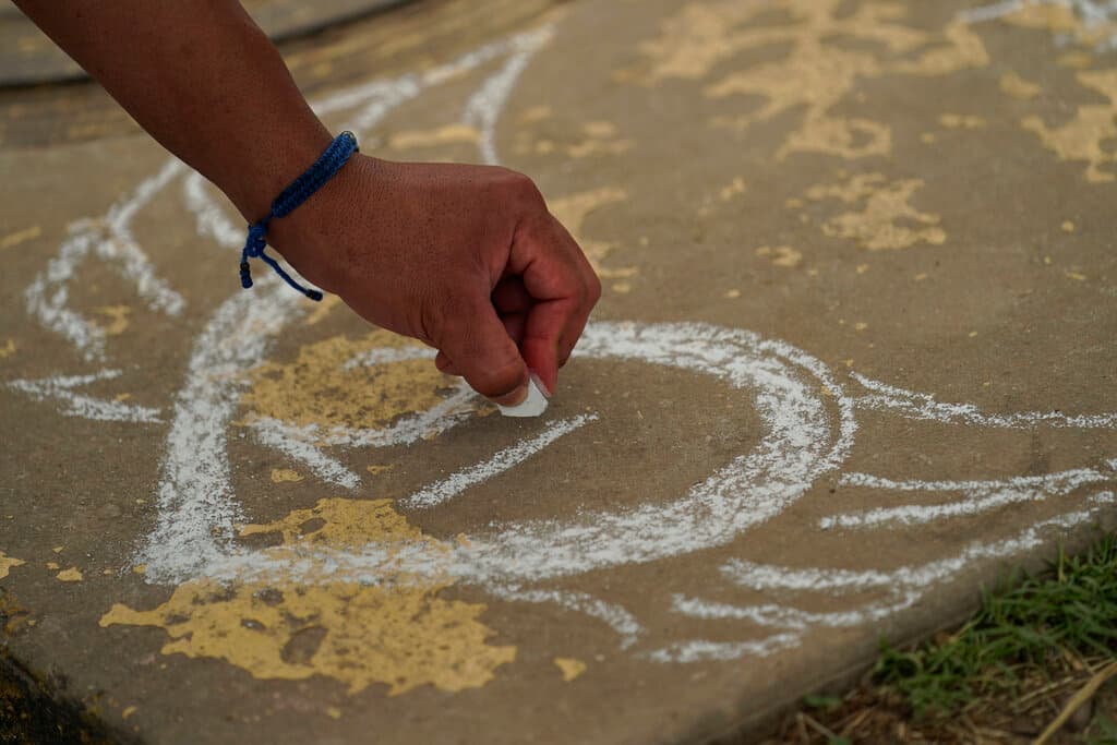 Un visitante dibuja en una calle un corazón con alas y el número 21, en recuerdo de las víctimas del tiroteo en la escuela Robb.