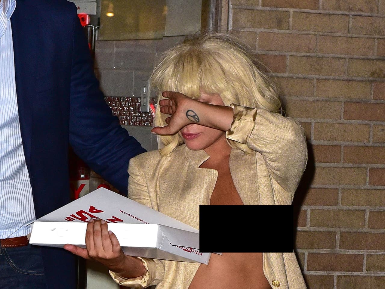 Y cuando levantó su mano para cubrirse de los paparazzi, dejó al aire uno de sus pechos.