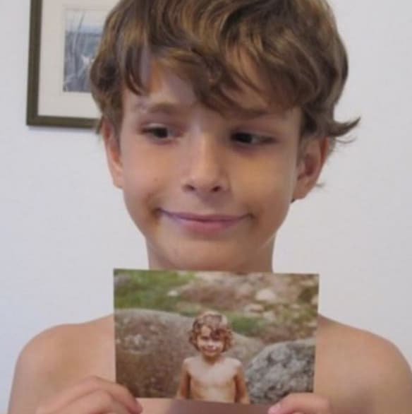 Su hijo Alex sosteniendo una foto de su papá y dice: "de tal palo tal astilla", pues son igualitos.