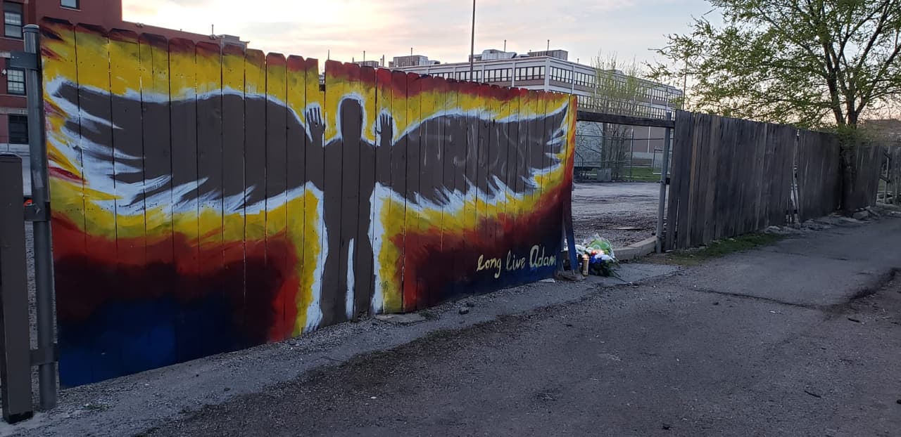 Los visitantes han dejado velas y flores cuando visitan el mural.