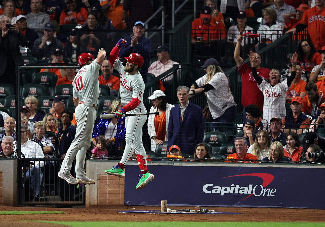 Después de
<b>caer 5-0 en la tercera entrada</b>, en gran parte debido a dos jonrones del jardinero de los Astros,
<b>Kyle Tucker</b>, los
<b>Phillies</b> se abrocharon el cinturón y se abrieron empatando gracias al
<b> doblete</b> en el quinto de
<b> J.T. Realmuto</b>. El jardinero #10 y
<b>Bryce Harper</b> #3 celebran después de que Realmuto conectó un jonrón en la décima entrada.