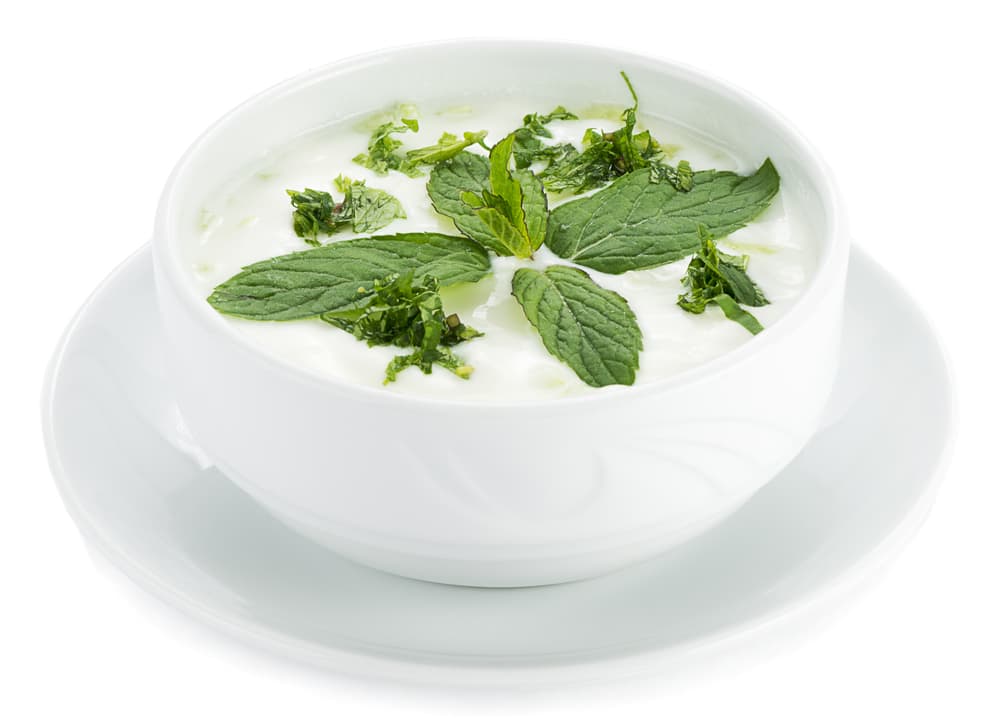 Ahora vamos a preparar la salsa de yogurt y menta, primero coloca las cebolletas, menta, eneldo, comino, pimienta roja, aceite de maíz y jugo de limón en la licuadora hasta que sea convierta en una pasta gruesa.