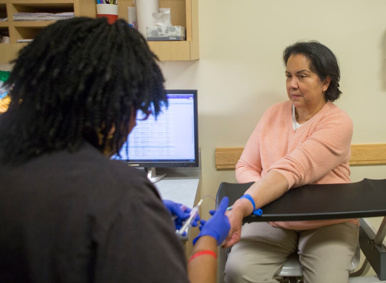 Irma Hendricks, right, has blood drawn at the Hospital of the University of Pennsylvania in Philadelphia, on Oct. 6, 2016. Hendricks received a kidney transplant from a donor with hepatitis C, and took medications after surgery that cleared away the virus and left her feeling healthy again. Hendricks is part of a pilot study testing if new drugs that promise to cure most hepatitis C could allow use of organs that today go to waste, and speed transplants to people who might otherwise die waiting. (AP Photo/Jessica Kourkounis)