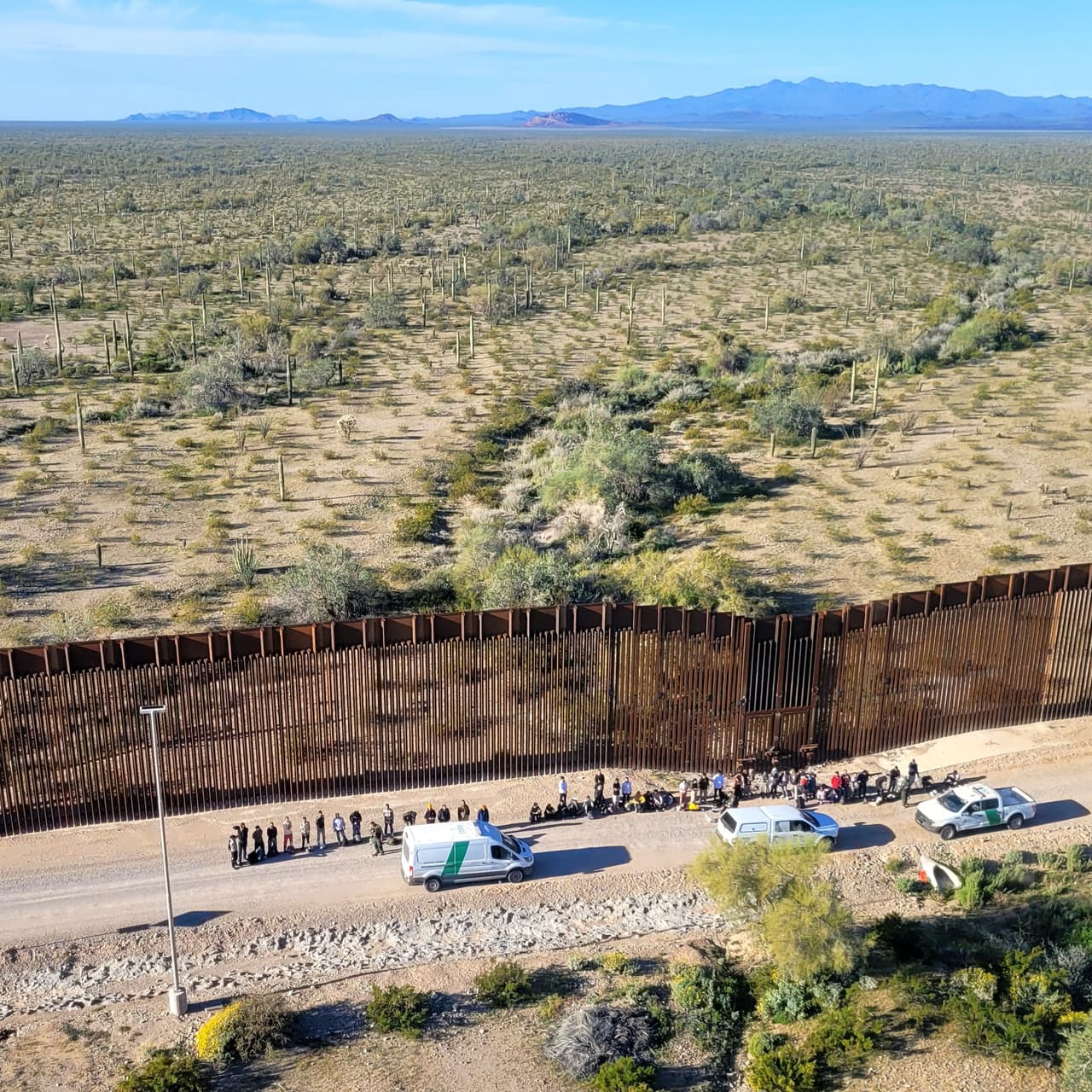 Debido al terreno remoto y accidentado, los grandes grupos de migrantes que cruzan al noroeste de Lukeville, Arizona, a menudo esperan varias horas antes de llegar a un centro de procesamiento, dijo John Modlin, jefe de la Patrulla Fronteriza del sector Tucson.