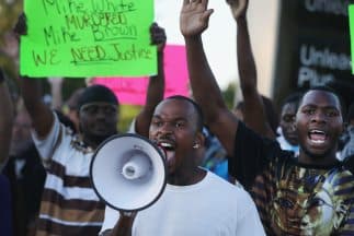 Residentes de Ferguson, Missouri, durante una protesta por la muerte, el sábado del joven afroamericano Michael Brown a manos de la policía de la ciudad.