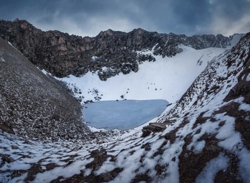 Una imagen compuesta por diferentes fotografías, muestra el lago Roopkund rodeado de montañas.