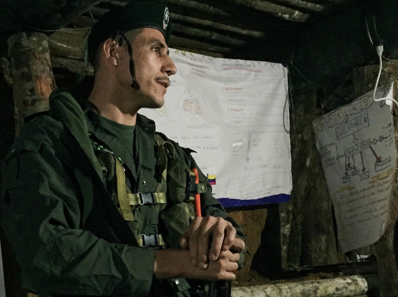A FARC guerrilla comments to fellow fighters on the peace process in an underground bunker at a rebel camp in southern Colombia