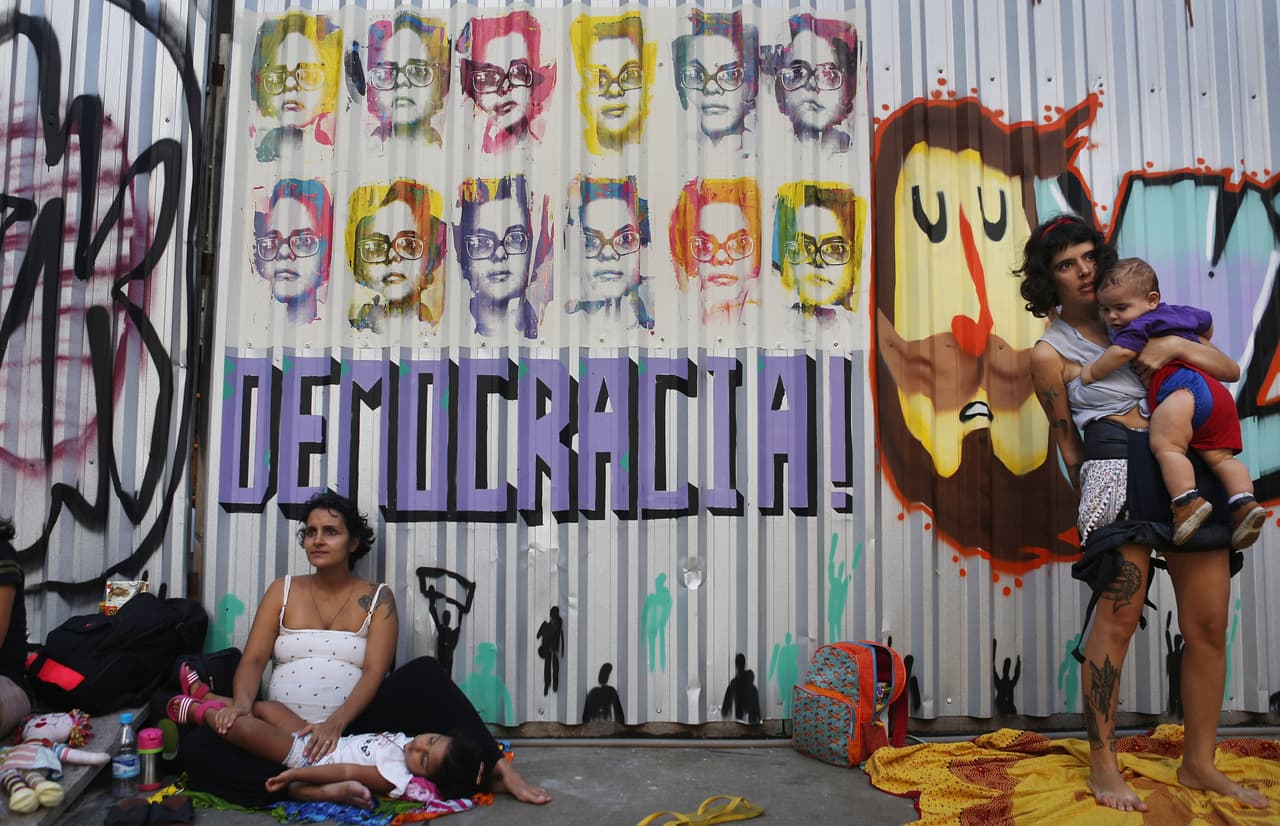 Manifestantes en contra del juicio político a la presidenta de Brasil, Dilma Rousseff, en frente a un grafiti que muestra la clásica imagen de la mandataria en su juventud como guerrillera.