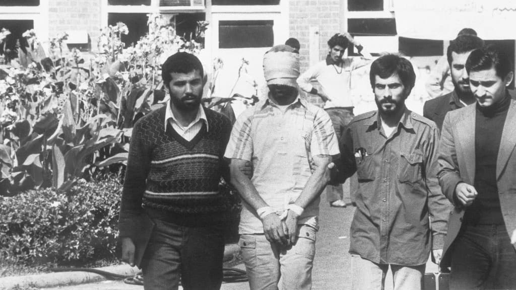 ARCHIVO - Uno de los rehenes retenidos en la Embajada de Estados Unidos en Teherán, Irán, es mostrado a la multitud por estudiantes iraníes el 8 de noviembre de 1979.