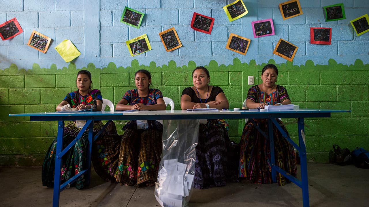 Trabajadoras electorales esperan a que la gente emita sus votos, en Chinautla, en las afueras de la ciudad de Guatemala, el domingo 11 de agosto de 2019.