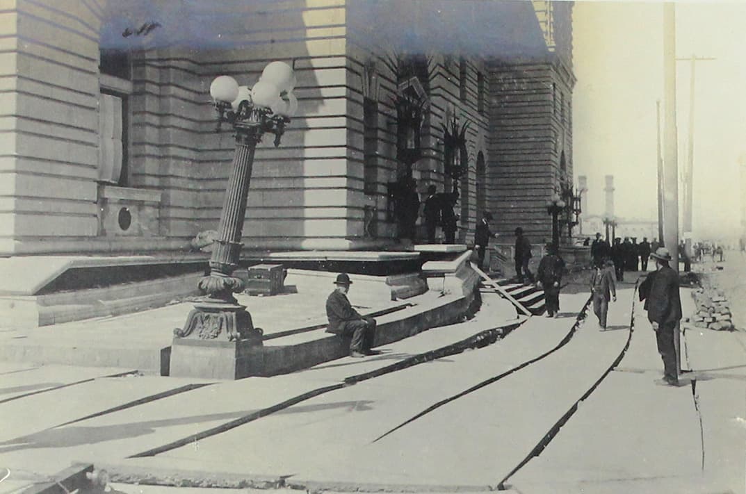 Un señor toma un breve receso al lado de un poste de luz que quedó inclinado.