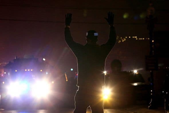 A manera de protesta, algunos jóvenes se coloraron frente a los autos de la policía con las manos en alto.