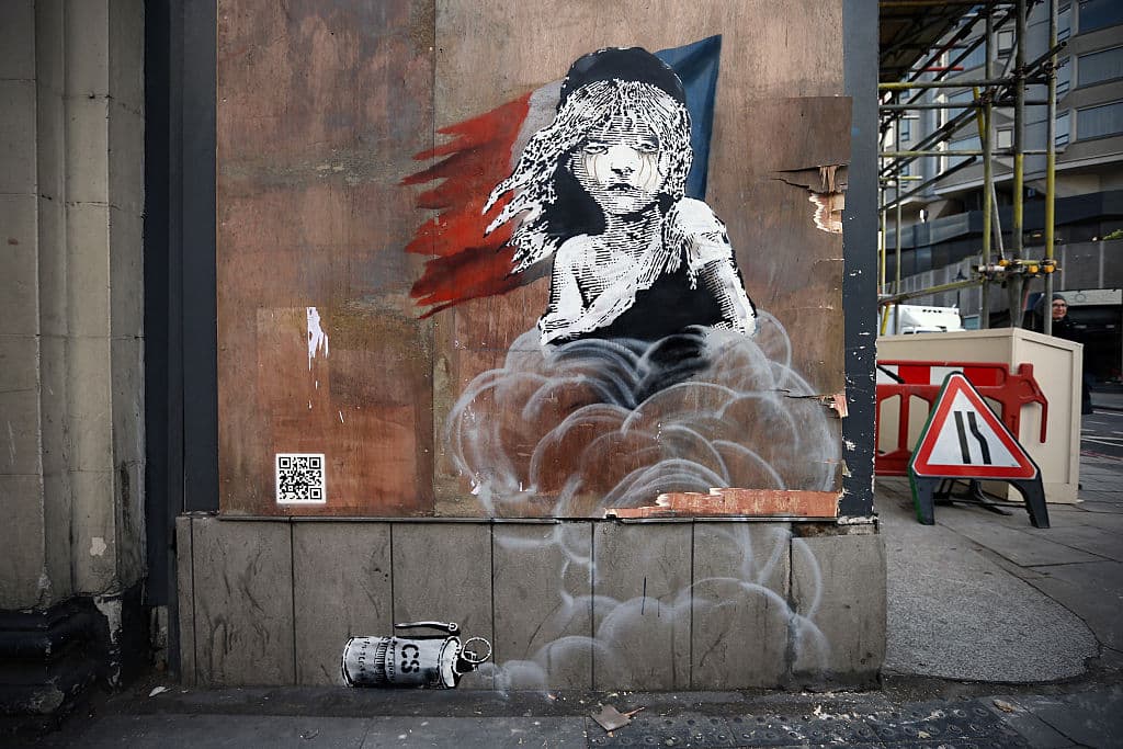 Banksy denunció con este grafiti el uso de gas lacrimógeno contra los refugiados del campo de Calais, Francia. La obra está inspirada en el cartel del musical Los Miserables, y apareció frente a la embajada francesa en Londres.