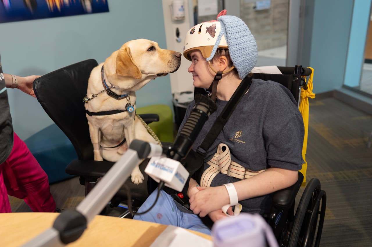 Grover, el perro de terapia del Hospital Infantil de Cincinnati (a la izquierda), observa a la paciente Kira Hodge en los estudios Seacrest del hospital mientras producen un programa de televisión de circuito cerrado que se transmite a las habitaciones de los pacientes, en el Hospital Infantil de Cincinnati, el lunes 4 de mayo de 2026. 
<br>