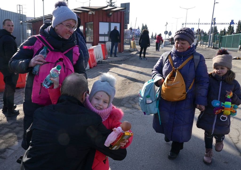 Un hombre abraza a una niña del lado polaco de la frontera con Ucrania.