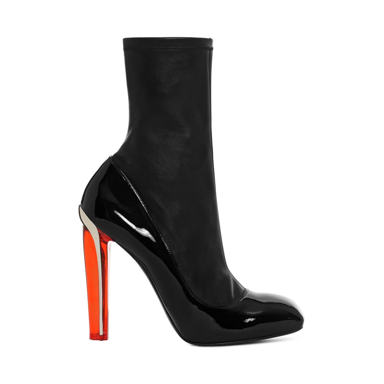 Alexander McQueen. ¿Es una zapatilla o una bota? El diseño de las Ankle Boots —que contrasta mate y brillante—, te hará cuestionarte. Además, su tacón metálico envuelto en rojo transparente, vuelve a esta pieza aún más interesante.