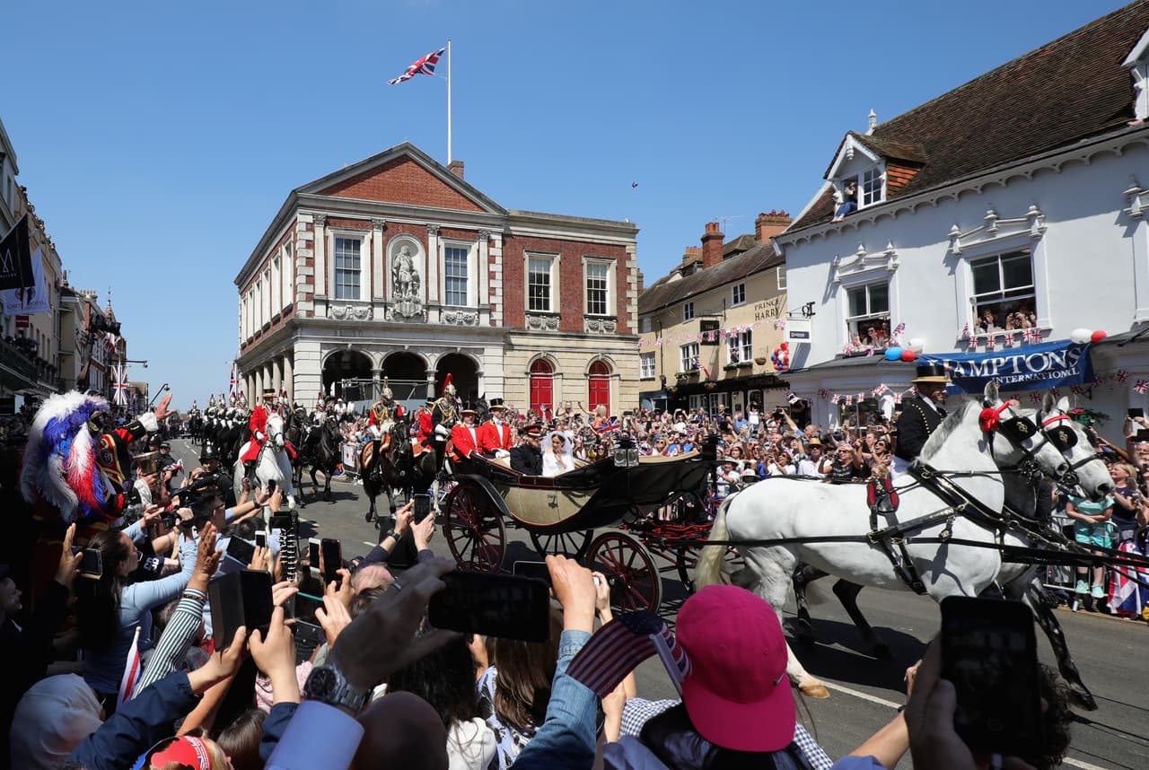 Miles de curiosos se acercaron a Windsor para saludar a los duques de Sussex tras su enlace. En esta fotografía se contempla el majestuoso carruaje tirado por dos corceles blancos mientras llueven las instantáneas en celulares.