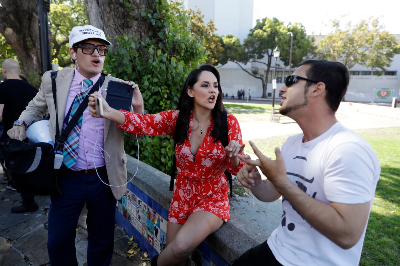 Jovi Val (izq) e Irma Hinojosa (en medio), quienes son simpatizantes de Trump, discuten con un opositor.