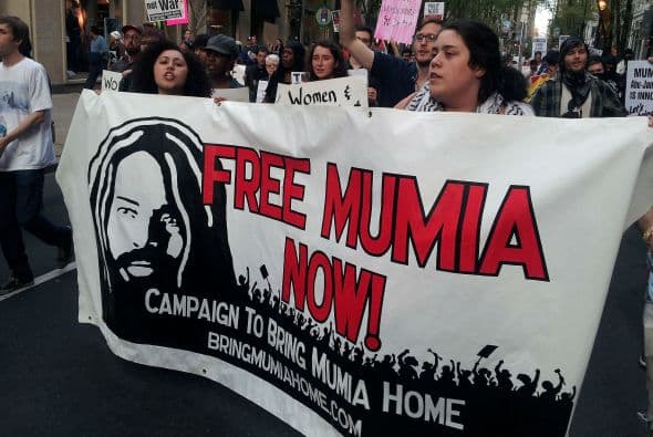 Parte de la manifestación incluyó la liberación del prisionero llamado Mumia. En los 80s, Mumia se le acusó y se le dió carg0s del asesinato de un policia en Filadelfia.