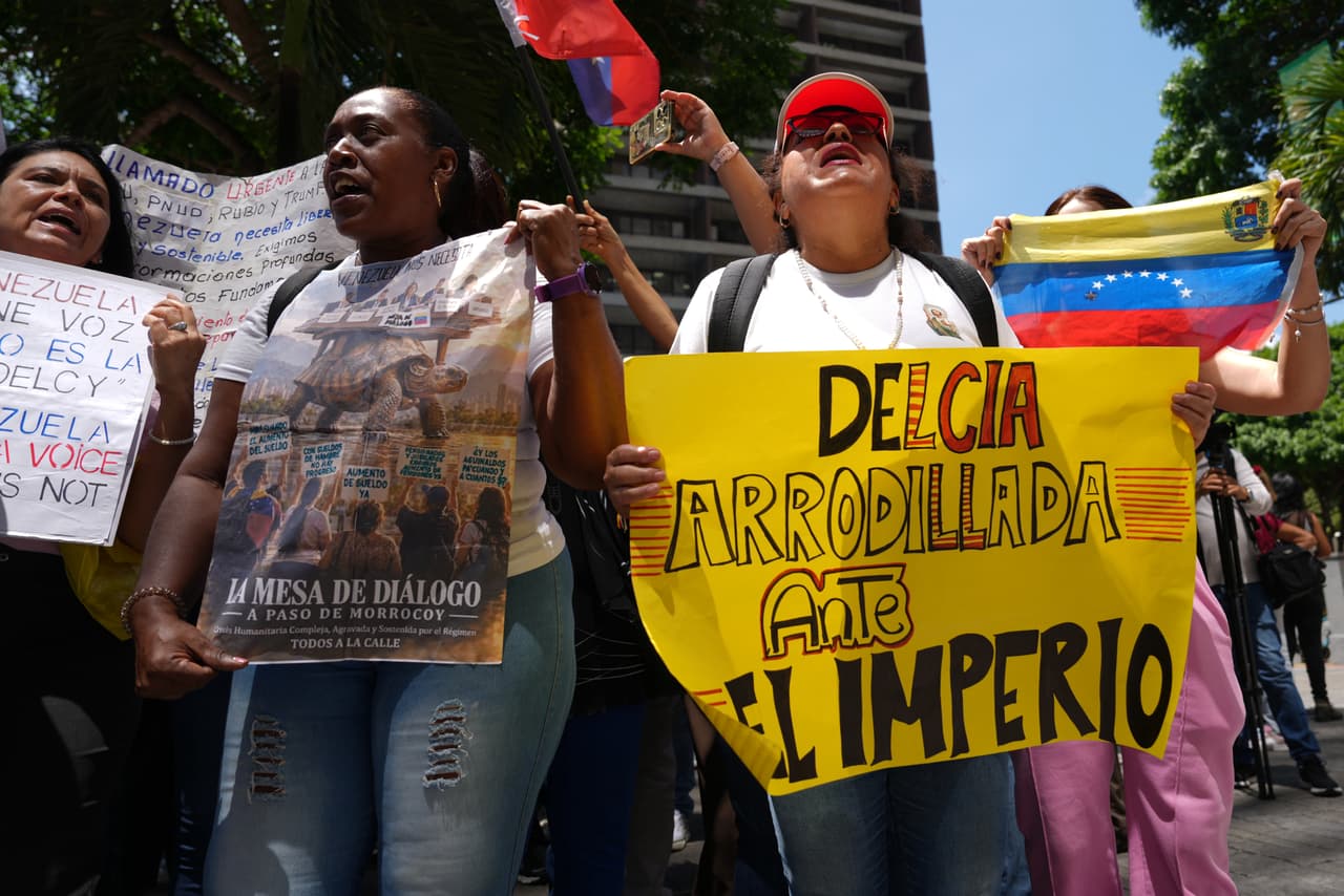 Demonstrators gather outside the United Nations headquarters in Caracas, Venezuela, to protest against acting Venezuelan President Delcy Rodriguez's participation at the United Nations General Assembly, Tuesday, Sept. 22, 2026. The sign at right read in Spanish: "Delcia kneels before the empire." (AP Photo/Ariana Cubillos)