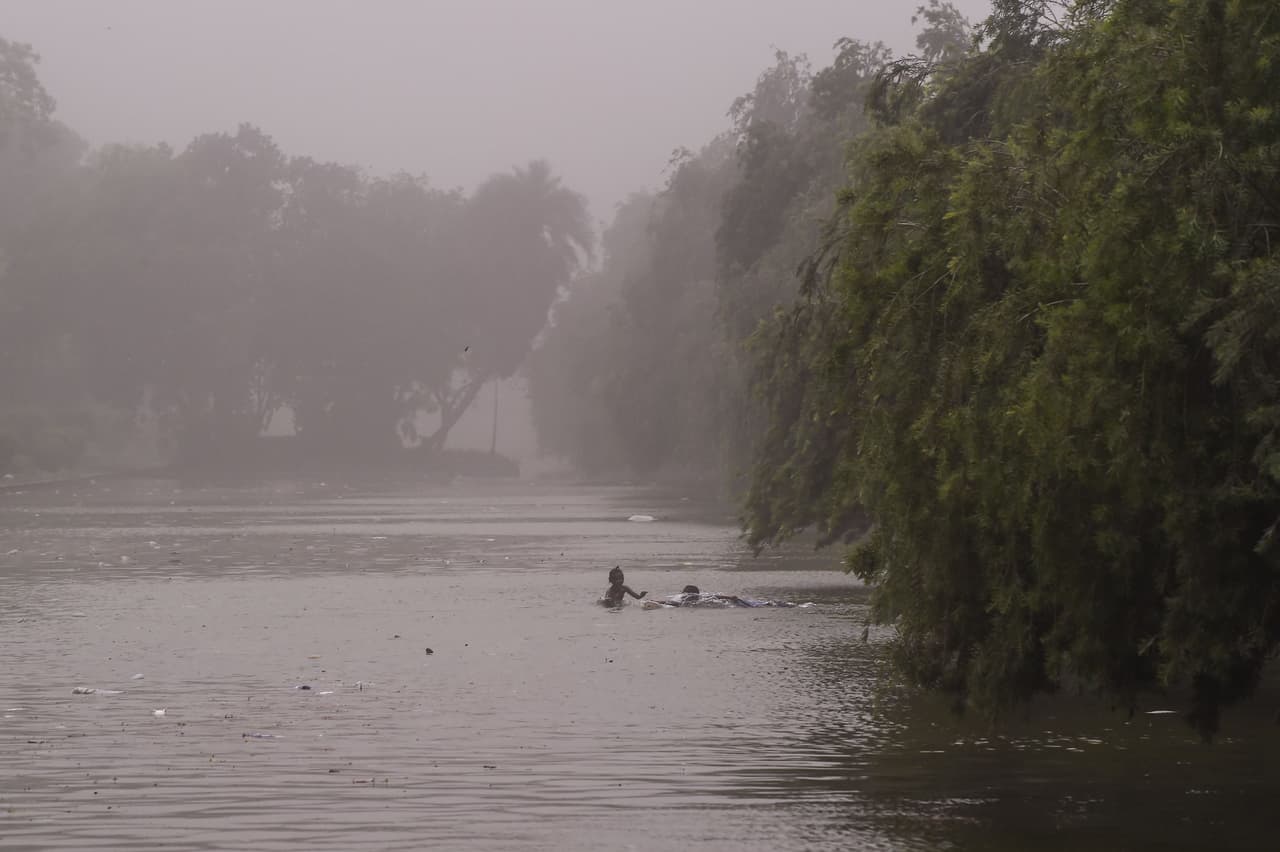 Niños en el agua durante la tormenta en Nueva Delhi.