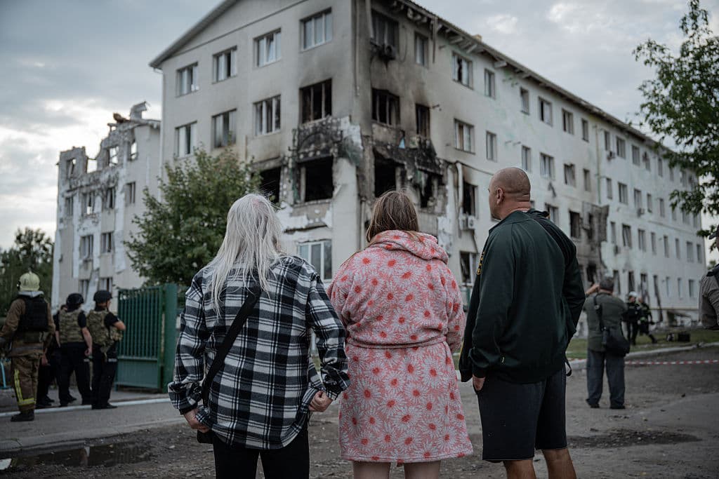 Residentes locales frente a un edificio residencial destruido tras un ataque aéreo en Járkov, el 18 de agosto de 2025, en medio de la invasión rusa de Ucrania. Un ataque con un dron ruso contra un bloque de apartamentos de cinco plantas en la ciudad ucraniana de Járkov, la madrugada del 18 de agosto de 2025, causó la muerte de al menos cinco personas y heridas a más de una docena, según informaron las autoridades ucranianas.