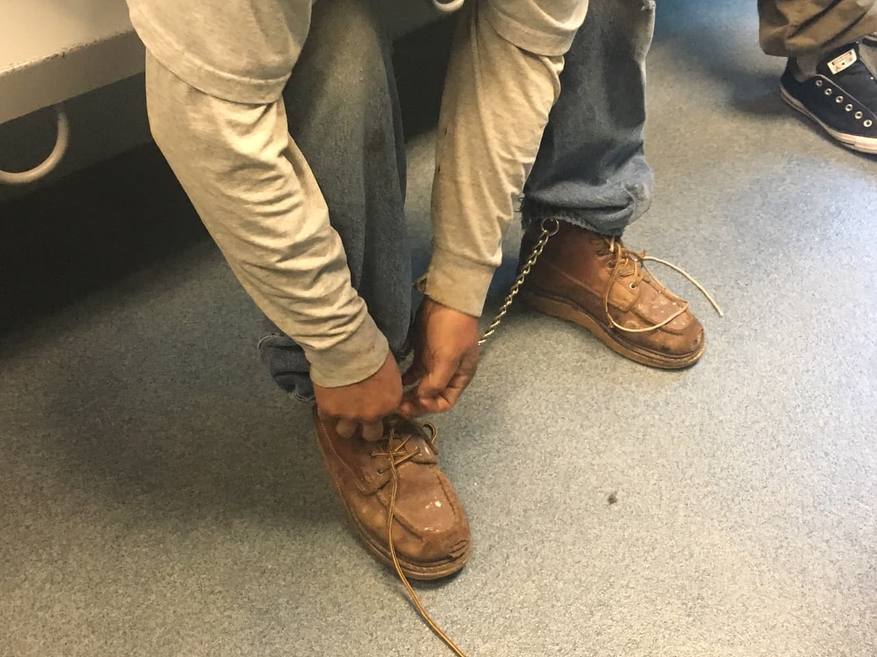 Carlos se quita las agujetas de sus botas antes de ser llevado a una celda.