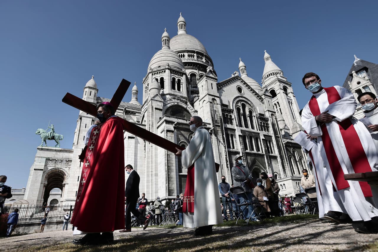 El arzobispo de París lleva una cruz de madera durante la ceremonia del Viernes Santo frente a la Basílica del Sagrado Corazón.