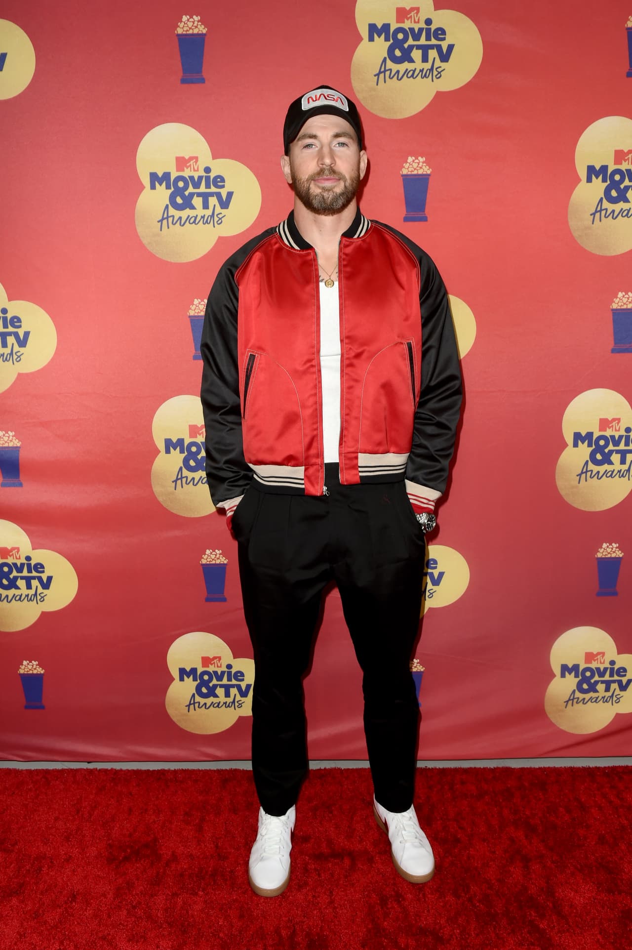 <b>Chris Evans</b> posó por la red carpet con un atuendo con estilo deportivo, el cual estuvo compuesto de una cazadora bomber satinada y pantalones a juego. Complementó su look con zapatillas deportivas Nike y una gorra con la leyenda 'Nasa'.