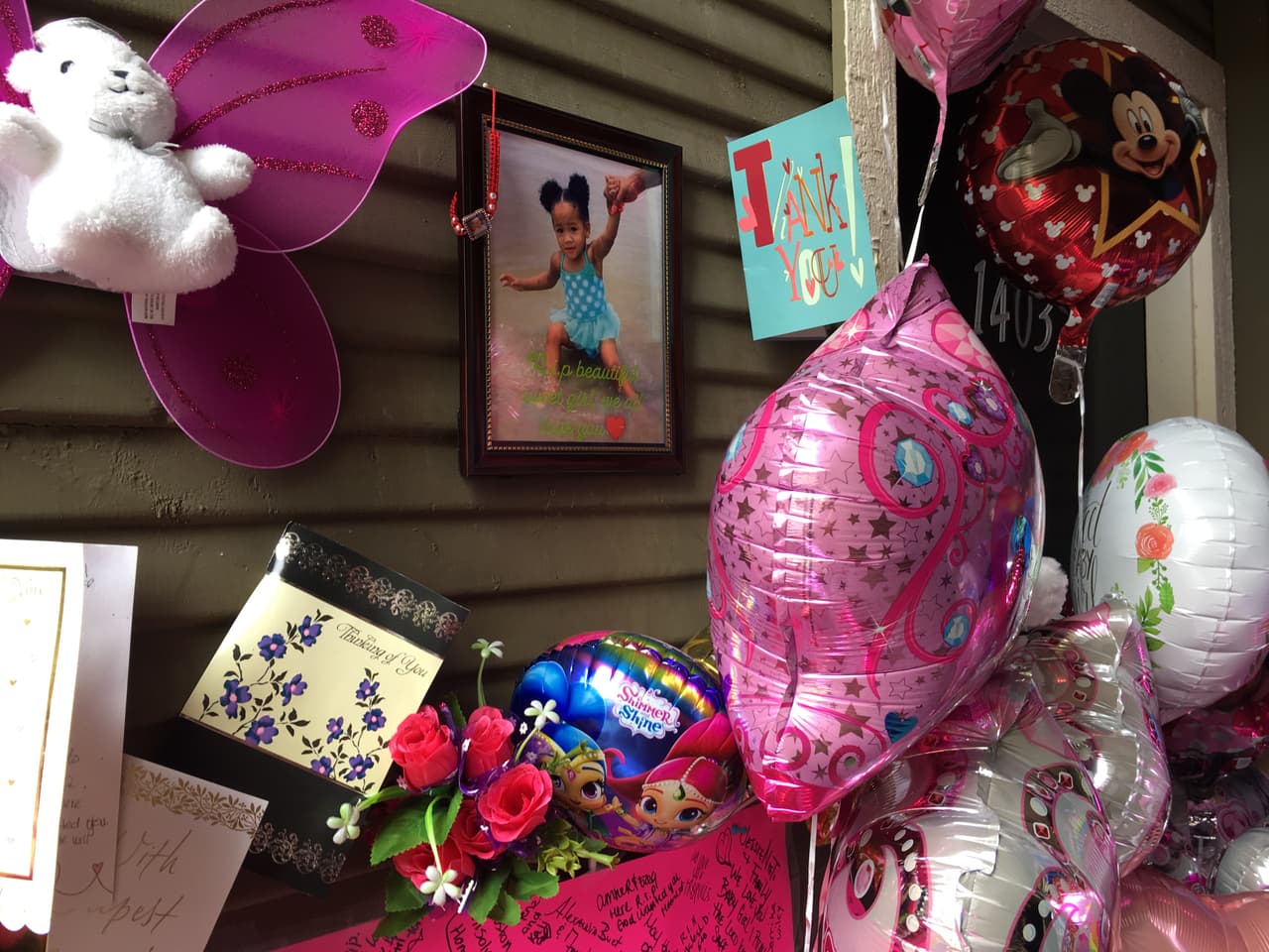 Así se ve el pasillo que lleva a la casa de Maleah Davis. La puerta de la vivienda quedó clausurada por los globos, flores y cartas que le han dejado los vecinos para recordarla.