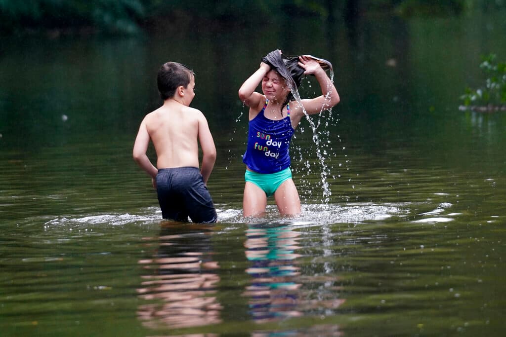 Marina Kingsmill y su hermana Raylan han sacado provecho a las aguas y se dan un baño en una calle de Slidell la mañana de este sábado.