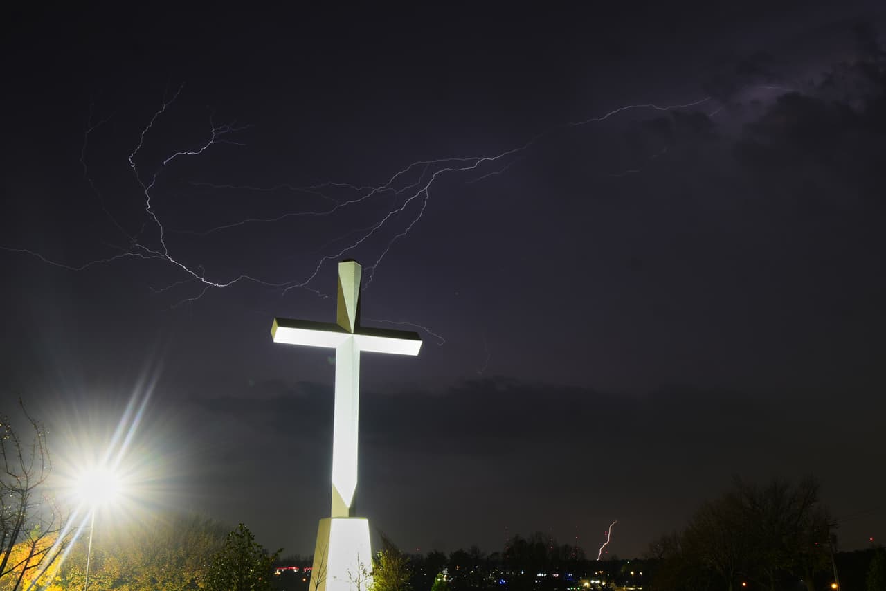 Se observa un relámpago en el cielo, cerca de una gran cruz en los terrenos de Life.Church, donde la Ruta 66 confluye con la Interestatal 35 en Edmond, Oklahoma.