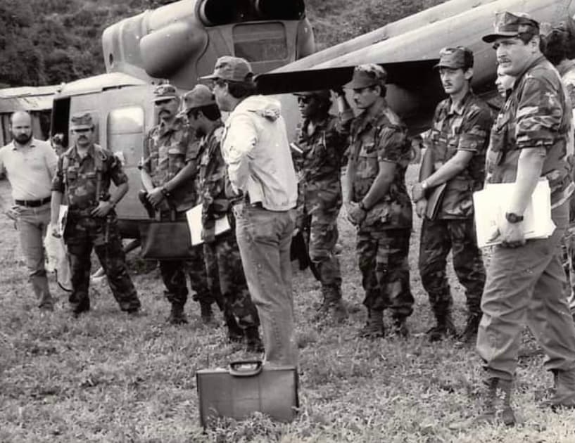 Former Contra commanders Luis Adán Fley, alias 'Jhonson' (fourth from right with hands folded) and Oscar Sobalvarro, alias 'Ruben' (third from right, also with hands folded) at a meeting in Honduras in the 1980s, stand at attention during a talk by their boss Colonel Enrique Bermúdez.