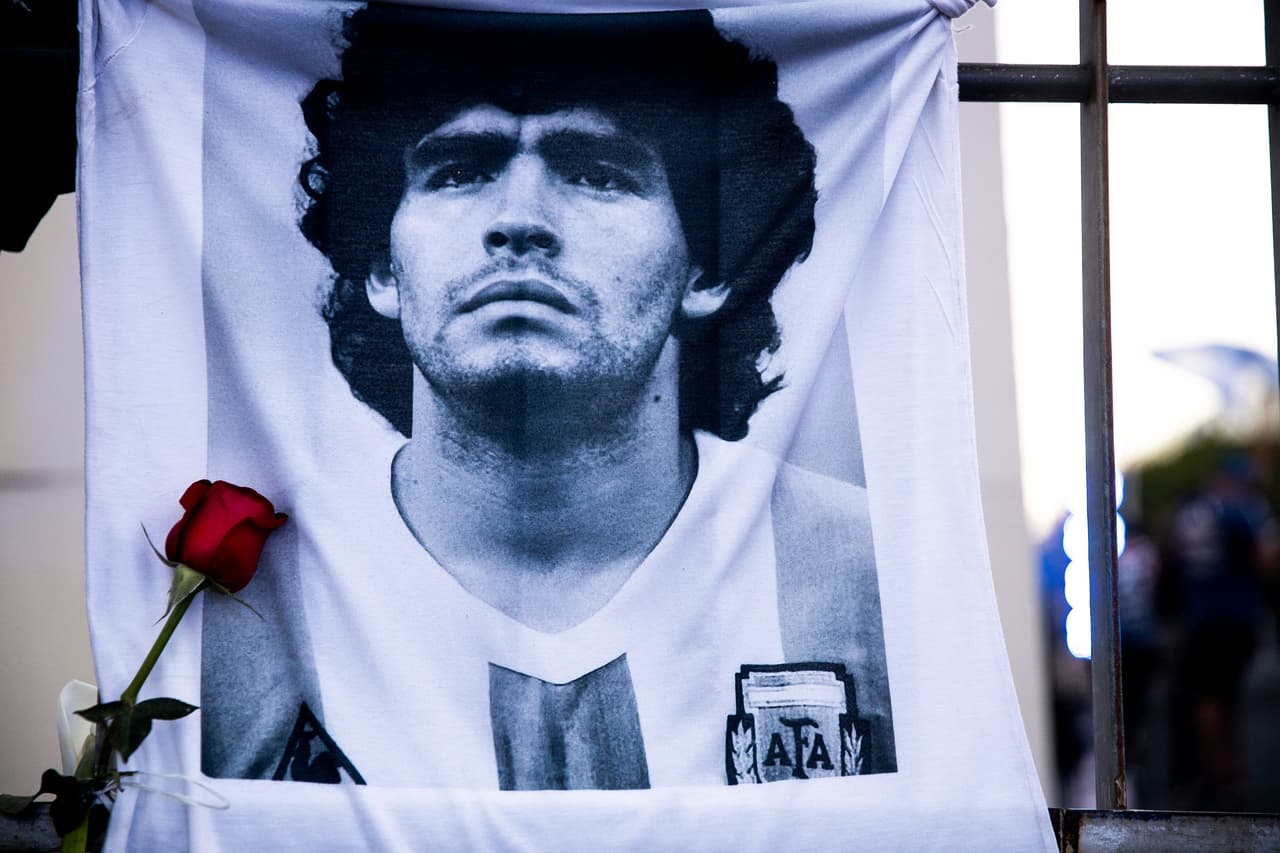 Una camiseta con el rostro de Maradona impreso cuelga de una reja en Buenos Aires, con una rosa roja en honor a la vida del campeón de la Copa Mundial de la FIFA en el Mundial de México 1986. 
<br>