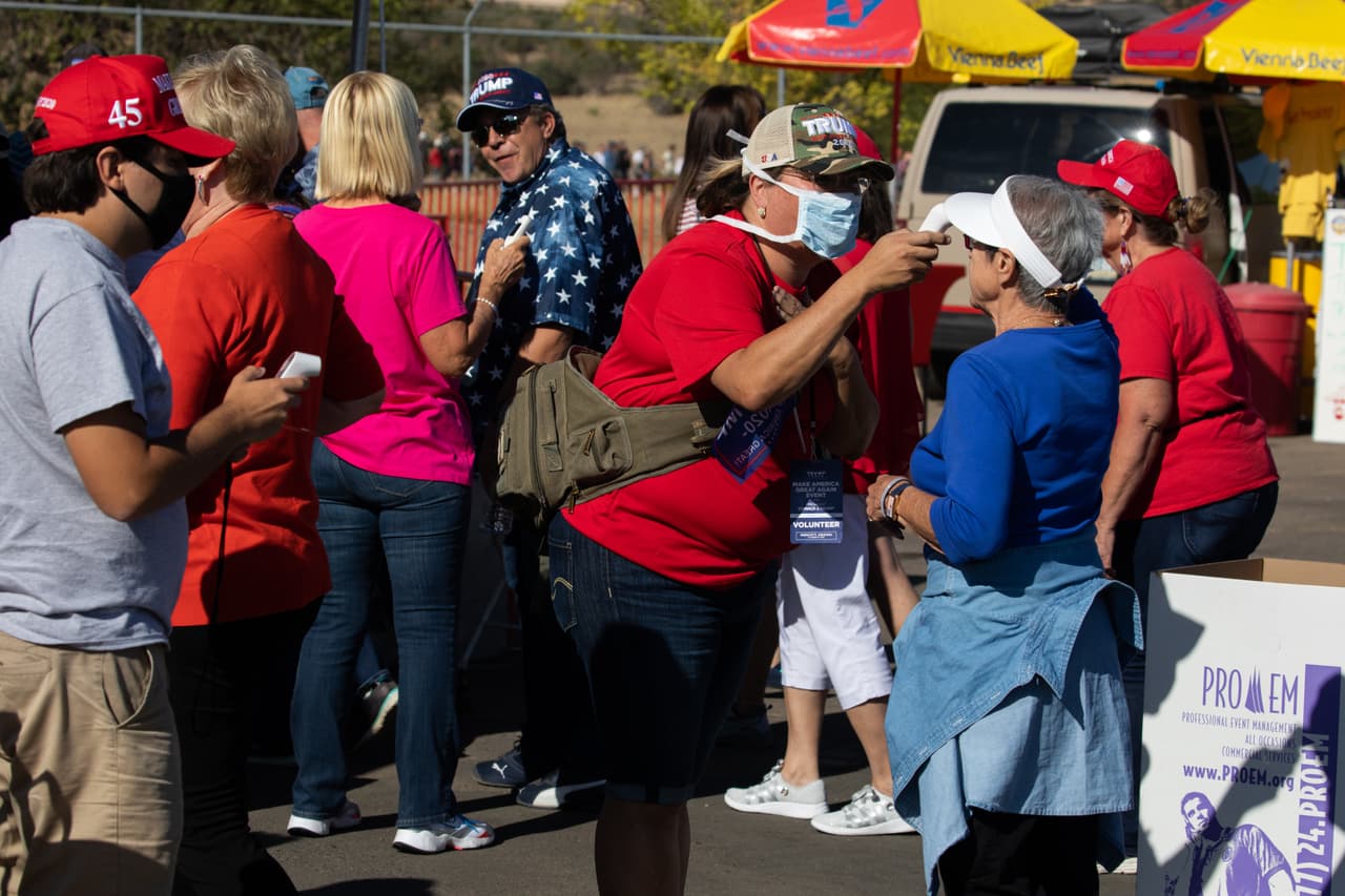 A las personas se les revisa la temperatura antes de asistir a un mitin de campaña "Make America Great Again" realizado por el presidente de Estados Unidos, Donald Trump, en el Aeropuerto Regional de Prescott el 19 de octubre de 2020 en Prescott, Arizona. Con casi dos semanas para las elecciones de noviembre, el presidente Trump está de regreso en la campaña con múltiples eventos diarios mientras continúa haciendo campaña contra el candidato presidencial demócrata Joe Biden.
