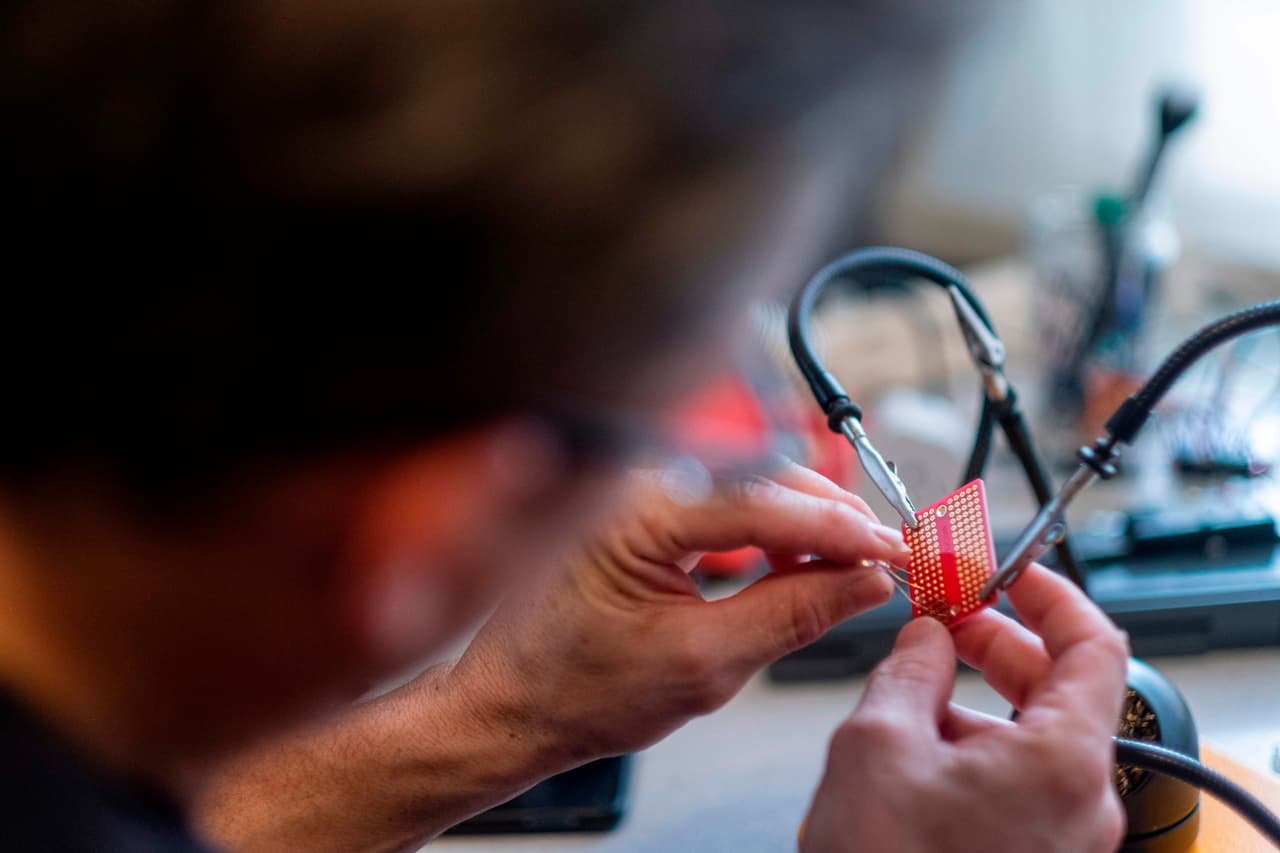 El Dr. Jonathan Alistair trabaja en una placa electrónica para un ventilador mecánico casero que está haciendo actualmente en su casa.