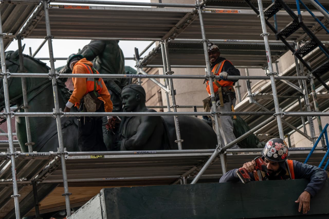 Un grupo de trabajadores prepara la estatua de Theodore Roosevelt a las afueras del Museo Americano de Historia Natural.