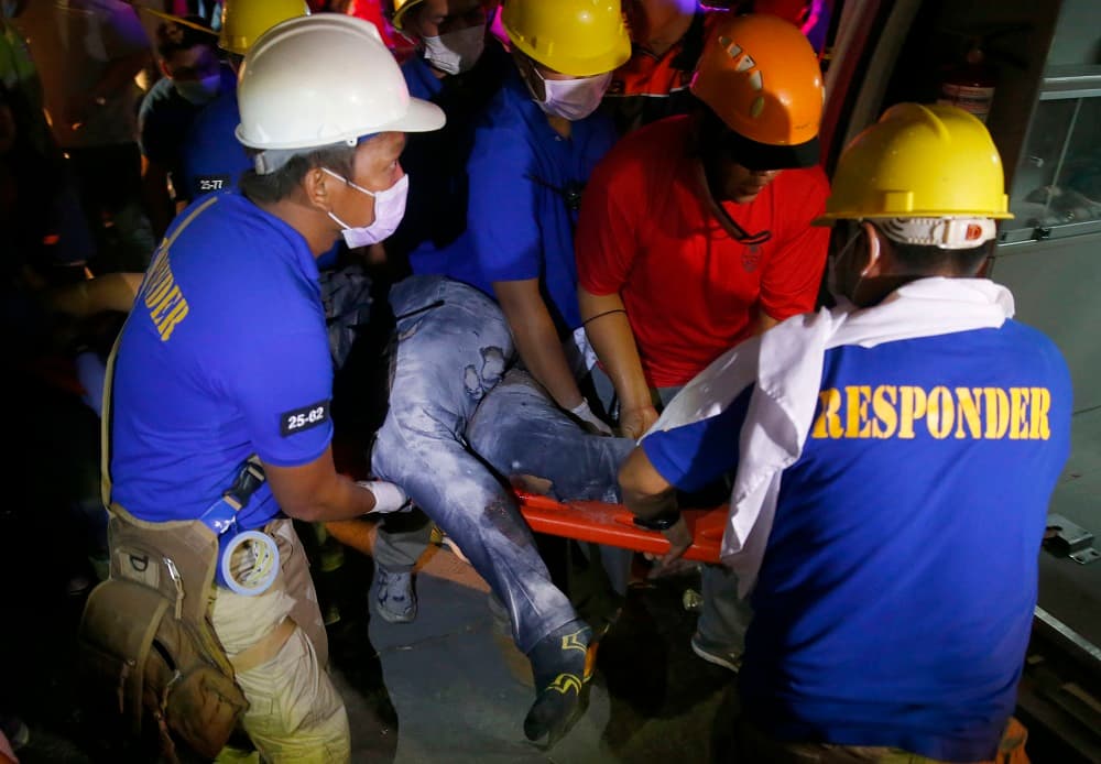 Al menos 11 personas, entre ellas un niño, murieron este lunes tras un fuerte terremoto en el norte de las Filipinas, que dejó a otras varias atrapadas y/o heridas. En la imagen, equipos de rescate cargan una víctima del sismo que hizo que colapsara un edificio en Porac, una de las ciudades más afectadas.