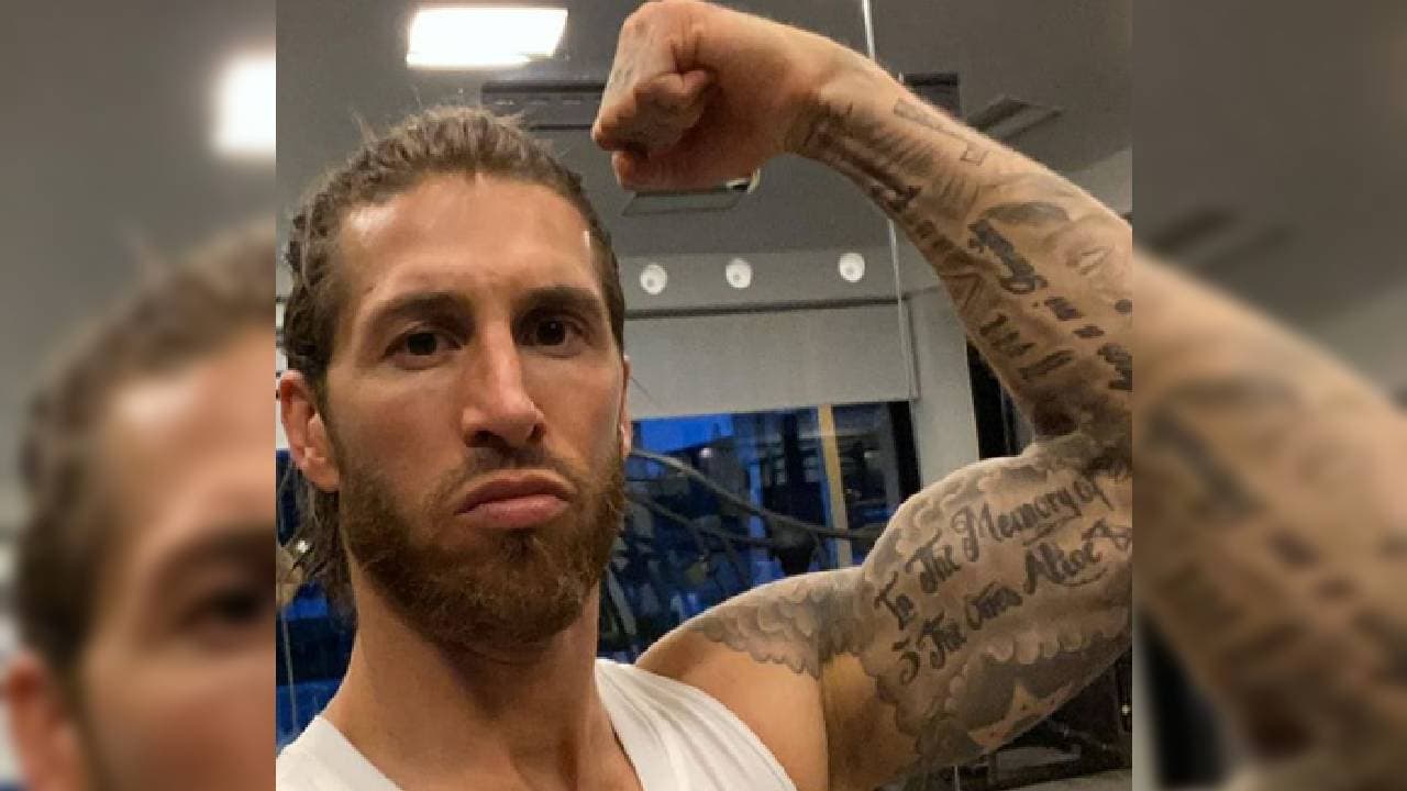 En su brazo izquierdo destacan palabras sobre figuras.