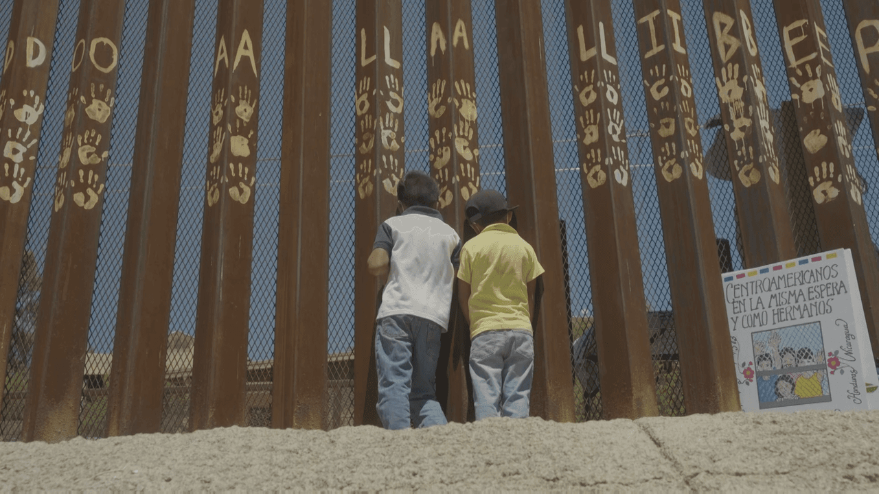 Children peer through the border fence in Nogales, Mexico.
