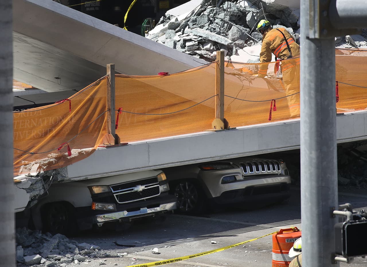 MIAMI, FL - MARCH 15: Vehicles are seen trapped under the collapsed pedestrian bridge that was newly built over southwest 8th street allowing people to bypass the busy street to reach Florida International University on March 15, 2018 in Miami, Florida. Reports indicate that there are an unknown number of fatalities as a result of the collapse, which crushed at least five cars. (Photo by Joe Raedle/Getty Images)