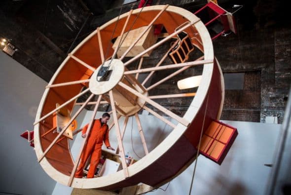 Hay veces que la monotonía de la vida se siente como una rueda de hámster gigante. De eso se trata el último performance de los artistas Ward Shelley y Alex Schweder de Brooklyn, quienes crearon una rueda de hámster de tres pisos en la que tendrán que coordinar cada movimiento durante 10 días. El performance llamado "En "rbita", está ubicado en una antigua sala de calderas en Williamsburg. Durante el performance, Schweder y Shelley van a comer, dormir, trabajar, ir al baño, etc, sin bajar de la rueda.