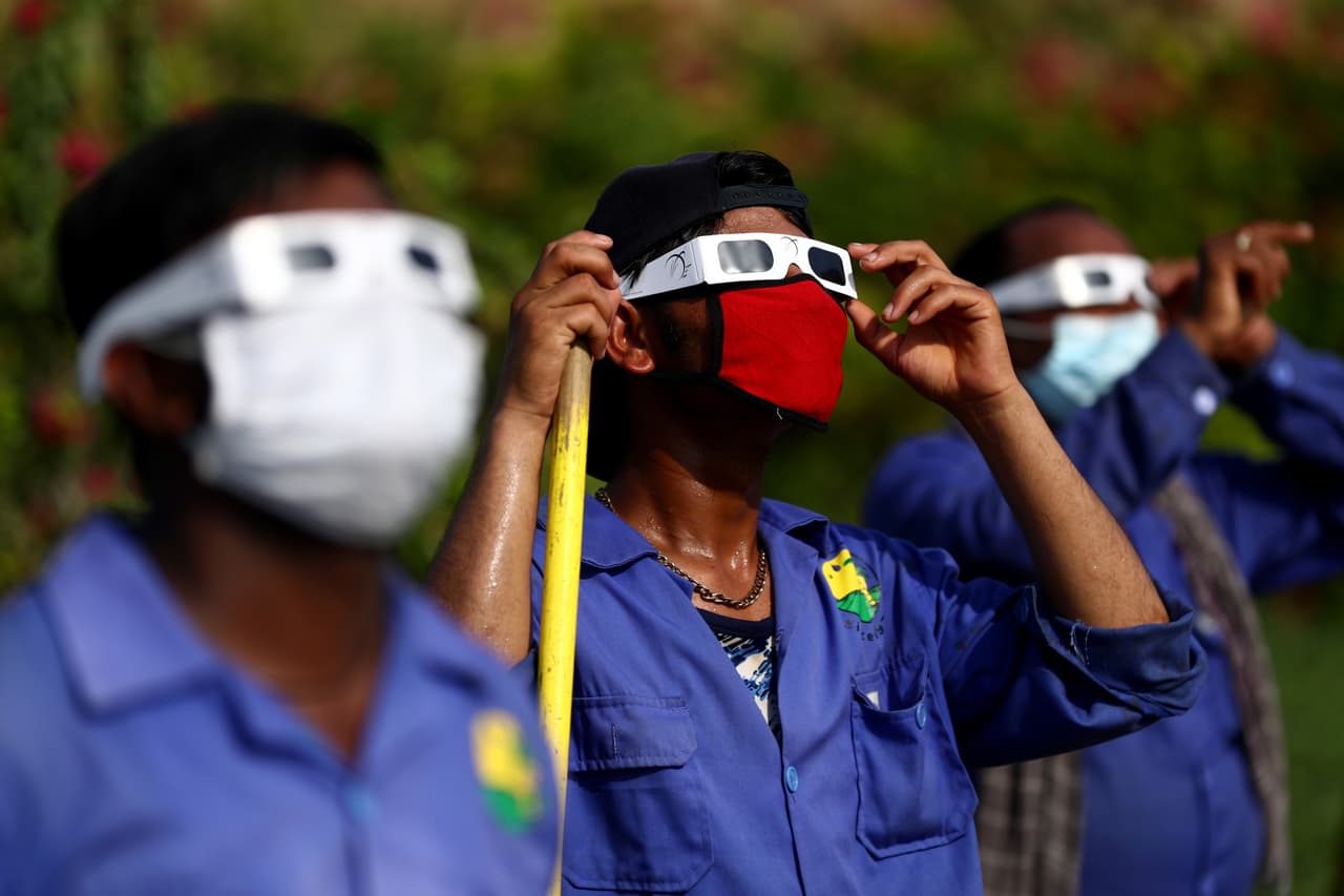 Los eclipse anulares se producen cuando la Luna llena se coloca justo delante del Sol sin taparlo por completo, lo que crea una especie de aureola brillante o anillo de fuego alrededor de nuestro satélite. Trabajadores del Centro Astronómico Al Thuraya, en Dubai, Emiratos Árabes Unidos. observan el eclipse parcial de sol con lentes especiales.