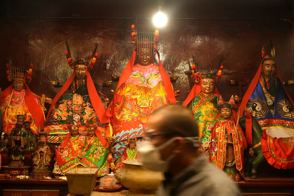 La pandemia ha limitado el tamaño de las celebraciones pero no las ha impedido. Son las estampas de siempre, 
<b>entre estatuas de dioses chinos</b> como en la fotografía, pero con la sempiterna mascarilla.