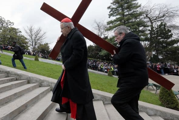 El arzobispo de París, Andre Vingt-Trois carga una cruz mientras se dirige a la basílica de Montmartre.