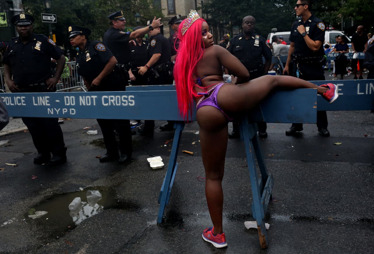 Una participante del desfile baila cerca de la policía