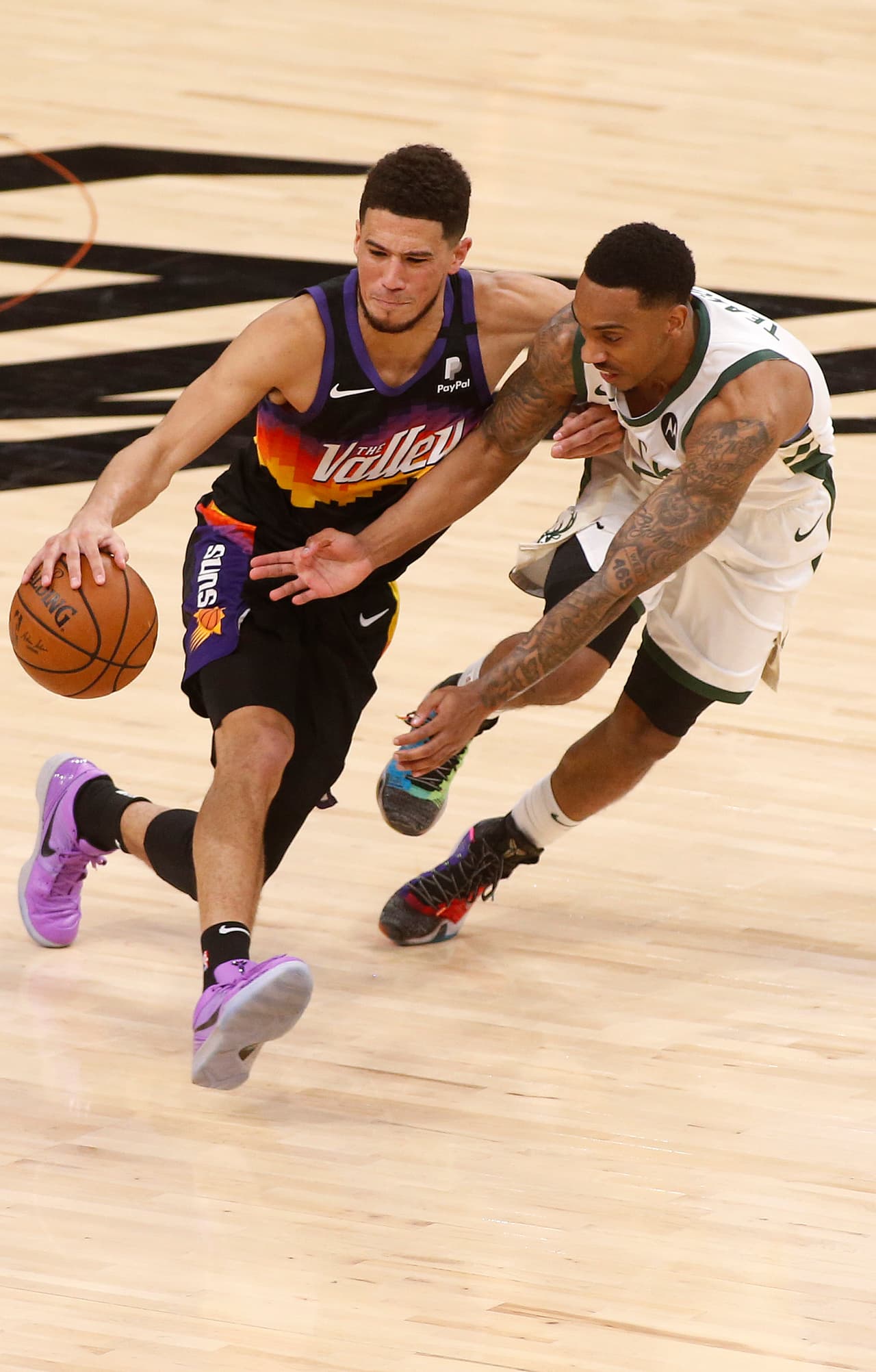 Jeff Teague # 5 de los Milwaukee Bucks presiona a Devin Booker # 1 de los Phoenix Suns durante la primera mitad del Juego Dos.