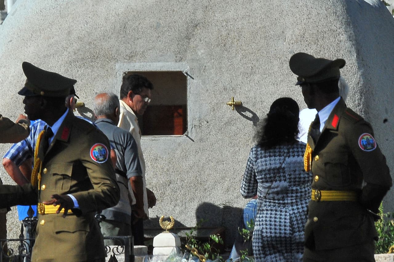Trabajadores colocan la urna con las cenizas de Fidel Castro en su tumba del cementerio Santa Ifigenia de Santiago de Cuba.